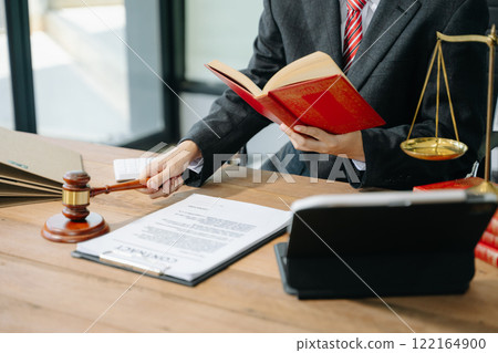 Woman lawyer reading legal book with gavel on table in office. justice and law ,attorney concept. 122164900