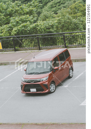 A woman getting into a car parked in a parking lot 122164991