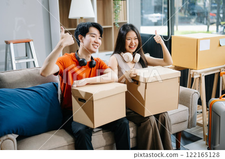 attractive couple man and woman with big boxes moving into a new house, new apartment for couple the new home, Moving house. 122165128