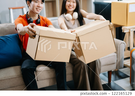 attractive couple man and woman with big boxes moving into a new house, new apartment for couple the new home, Moving house. 122165129