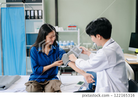 Asian male patient on bed while doctor hands of checking examining his pulse for record the treatment results Asian male patient on bed while doctor hands of checking examining his pulse for record the treatment results 122165316