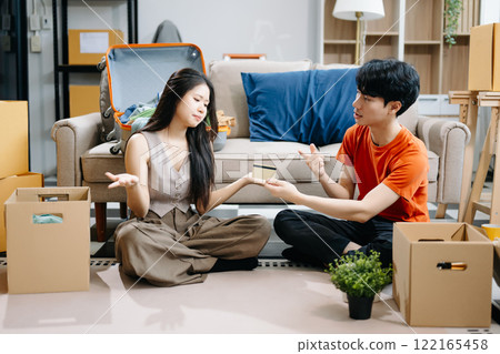 Asian young attractive couple man and woman use tablet and smartphone online shopping furniture decorate house with carton package move Asian young attractive couple man and woman use tablet and smartphone online shopping furniture decorate house with carton package move 122165458