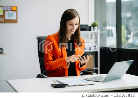 Business woman sitting at a desk using a laptop computer Navigating Finance and Marketing with Technology 122165938