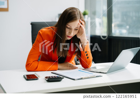woman feeling migraine head strain.Overworked businesswoman finanwhile working on laptop and tablet at office. woman feeling migraine head strain.Overworked businesswoman finanwhile working on laptop and tablet at office. 122165951