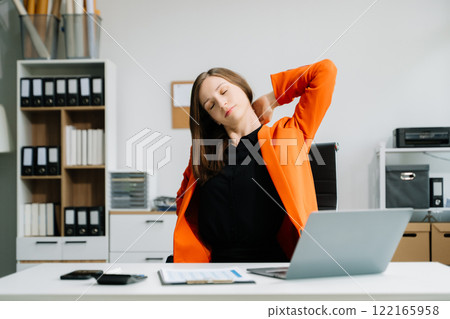 Overworked young Asian businesswoman office worker suffering from neck pain after had a long day at her office Overworked young Asian businesswoman office worker suffering from neck pain after had a long day at her office 122165958