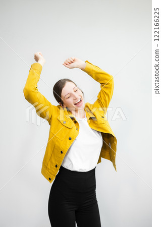 Young woman 20s wears casual clothes stand on toes dance lean back have fun spreading hands isolated on plain light white background studio portrait 122166225
