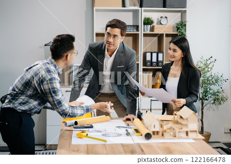 Engineer teams meeting working together wear worker helmets hardhat with on architectural project site and making model house. Engineer teams meeting working together wear worker helmets hardhat with on architectural project site and making model house. 122166478