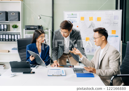 Office colleagues have a casual discussion. During a meeting in a conference room, a group of business teem 122166880