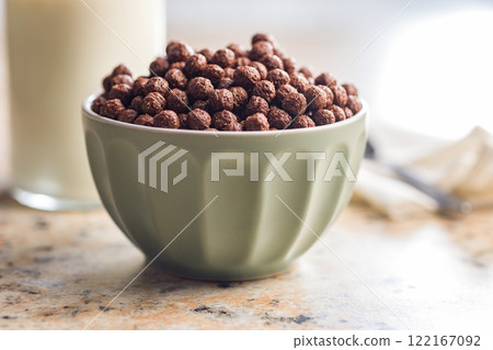 Breakfast cereal chocolate balls in bowl on kitchen table. 122167092