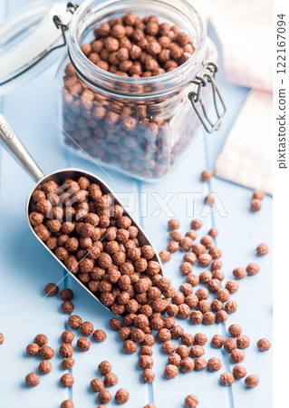 Breakfast cereal chocolate balls in scoop on blue table. Breakfast cereal chocolate balls in scoop on blue table. 122167094