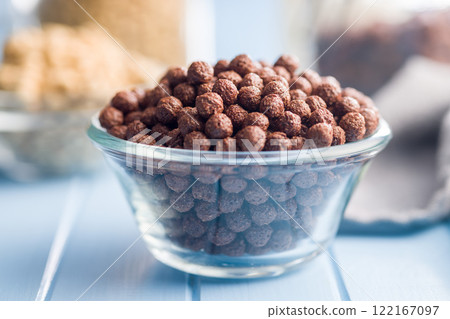 Breakfast cereal chocolate balls in bowl on blue table. Breakfast cereal chocolate balls in bowl on blue table. 122167097