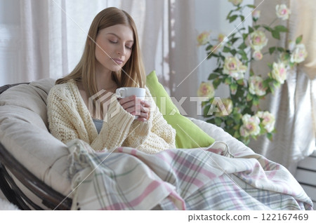 Portrait of young woman in pajamas on bed with fluffy plaid Portrait of young woman in pajamas on bed with fluffy plaid 122167469