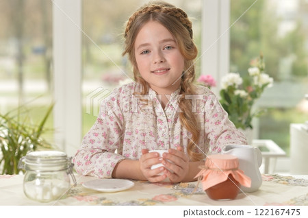 Smiling little girl holding big cup of tea Smiling little girl holding big cup of tea 122167475
