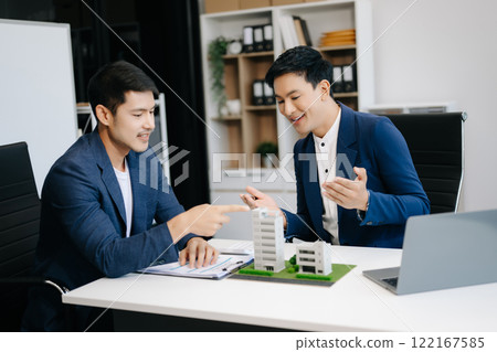 balancing the property sector The real estate agent is explaining the house style to see the house design and the purchase agreement. model house balancing the property sector The real estate agent is explaining the house style to see the house design and the purchase agreement. model house 122167585