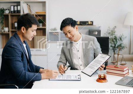Business people compassionately holding hands and discussing contract papers with laptop and tablet at office room. 122167897