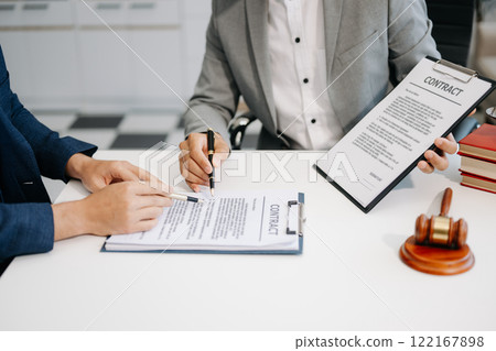 Business people compassionately holding hands and discussing contract papers with laptop and tablet at office room. 122167898