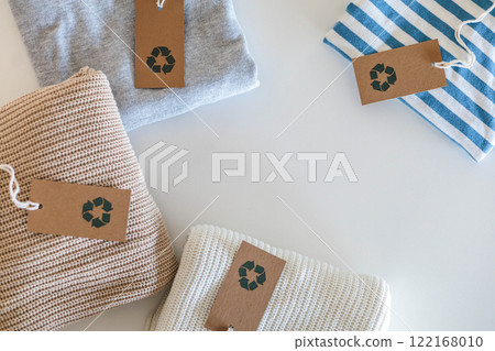 Folded cotton knitted clothes recycling made reusing material craft tag top view isolated on white 122168010