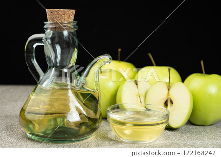 Apple cider vinegar in a glass vinegar bowl among apples 122168242