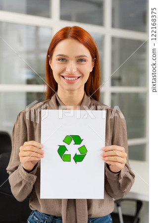 Smiling young woman presenting a waste recycling project Smiling young woman presenting a waste recycling project 122168375