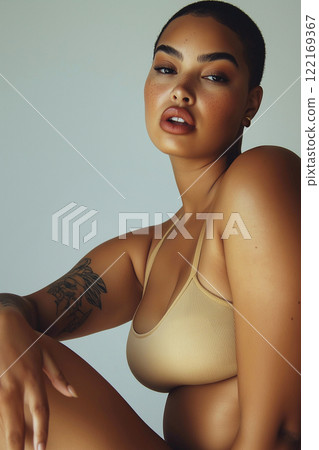 Beautiful and confident plus size woman with curly hair and freckles, posing under warm natural light. She is wearing stylish swimwear, body positive, perfect curly body. 122169367