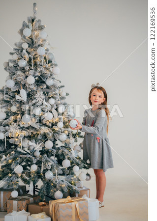 Cute little girl decorating christmas tree. Cute little girl decorating christmas tree. 122169536