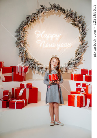 Cute little girl with red gift box in christmas decor. Cute little girl with red gift box in christmas decor. 122169615