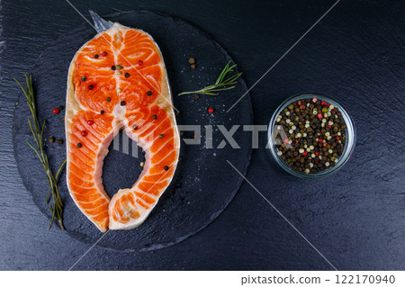 Raw salmon steak with spices on black slate. Top view Raw salmon steak with spices on black slate. Top view 122170940