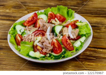 Tasty tuna salad with lettuce and fresh vegetables on wooden table Tasty tuna salad with lettuce and fresh vegetables on wooden table 122170967