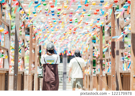 Back view of a young woman enjoying the wind chime festival at Kasui-sai temple Back view of a young woman enjoying the wind chime festival at Kasui-sai temple 122170978