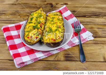 Baked stuffed eggplants on a wooden table. Healthy food and dieting concept Baked stuffed eggplants on a wooden table. Healthy food and dieting concept 122171089