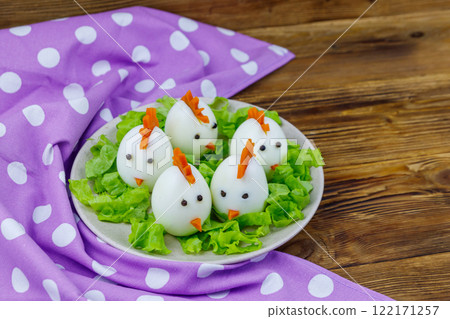 Funny easter breakfast with boiled eggs as chicks on wooden table 122171257