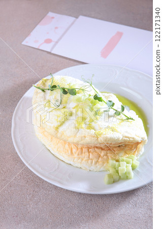 An airy omelet on a white plate. Italian omelet. Healthy breakfast. An exquisite presentation. An airy omelet on a white plate. Italian omelet. Healthy breakfast. An exquisite presentation. 122171340