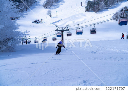 [Winter material] Skiers and snowboarders skiing down the slopes [Nagano Prefecture] 122171707