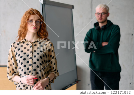 A business colleague collaboratively presenting business goals and strategies to their team in a professional office setting 122171952