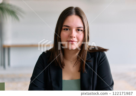 A close up portrait of a young businesswoman engaged in a professional meeting, confidently discussing ideas and strategies with her colleagues 122171987