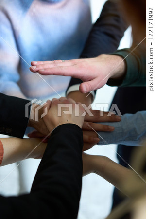 A top view of business people joining hands in a circle, symbolizing unity, collaboration, and shared success in the workplace 122171992