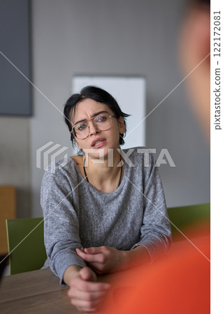 A close up portrait of a young businesswoman engaged in a professional meeting, confidently discussing ideas and strategies with her colleagues A close up portrait of a young businesswoman engaged in a professional meeting, confidently discussing ideas and strategies with her colleagues 122172081