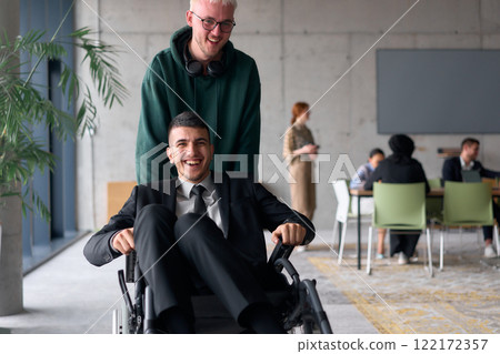 Employee Entertaining Director in a Wheelchair While Rolling Through the Office with Laughter and Joy. 122172357