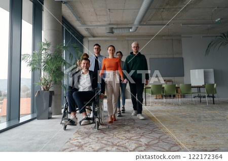A diverse group of business professionals walking together through the office, symbolizing unity and strength as a collaborative and successful team 122172364