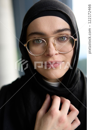 A stunning Muslim businesswoman is captured in a close-up portrait, showcasing her captivating green eyes behind stylish prescription glasses, radiating elegance and confidence A stunning Muslim businesswoman is captured in a close-up portrait, showcasing her captivating green eyes behind stylish prescription glasses, radiating elegance and confidence 122172466