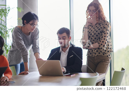 A diverse multiethnic business team engages in a collaborative meeting, discussing strategies and solutions in a modern office setting A diverse multiethnic business team engages in a collaborative meeting, discussing strategies and solutions in a modern office setting 122172468