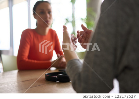 A young, diverse business team sitting together in a modern office, exchanging ideas and business plans, fostering collaboration and innovation for future success. 122172527