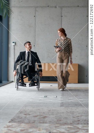 Director in a Wheelchair Navigating the Office While Discussing Business Challenges with a Colleague Director in a Wheelchair Navigating the Office While Discussing Business Challenges with a Colleague 122172692
