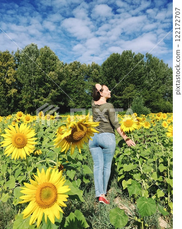 Young woman in a field of blooming sunflowers 122172707
