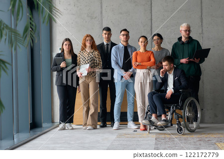 Multiethnic Business Team Collaborating in a Modern Office with Director in a Wheelchair Multiethnic Business Team Collaborating in a Modern Office with Director in a Wheelchair 122172779