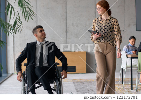 Director in a Wheelchair Engaging in a Business Discussion with a Colleague While Navigating a Modern Office 122172791