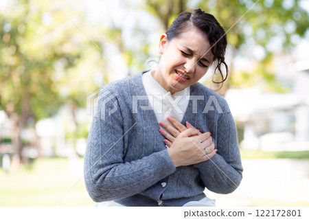 Caucasian woman chest pain in outdoor park, emergency of patient with injury. Caucasian woman chest pain in outdoor park, emergency of patient with injury. 122172801