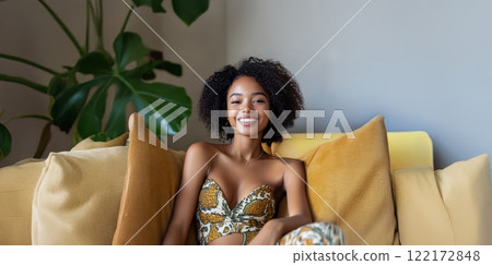 Young African woman with vitiligo smiling and relaxing on the sofa at home. Generated image 122172848
