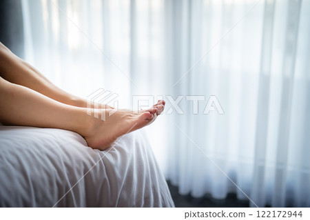 Close-up of a young woman's legs on the bed. Close-up of a young woman's legs on the bed. 122172944