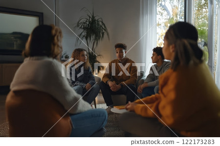 A school psychologist provides counseling to a diverse group of teenagers during a therapy session. Generated image 122173283